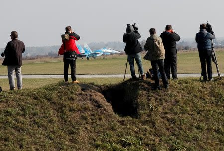 Journalists take pictures of a Ukrainian Su-27 fighter jet during the Clear Sky 2018 multinational military drills at Starokostiantyniv Air Base in Khmelnytskyi Region, Ukraine October 12, 2018. REUTERS/Gleb Garanich