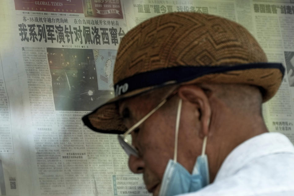 A man reads a newspaper with a photo of a plane carrying U.S. House Speaker Nancy Pelosi lands at Songshan Airport in Taipei, Taiwan with a headline reporting "Our series of military exercises are aimed at Pelosi channeling Taiwan" at a stand in Beijing, Wednesday, Aug. 3, 2022. After weeks of threatening rhetoric, China stopped short of any direct military confrontation with the U.S. over the visit of Pelosi to Taiwan. The response disappointed some Chinese, who asked why no action was taken to stop her. (AP Photo/Andy Wong)