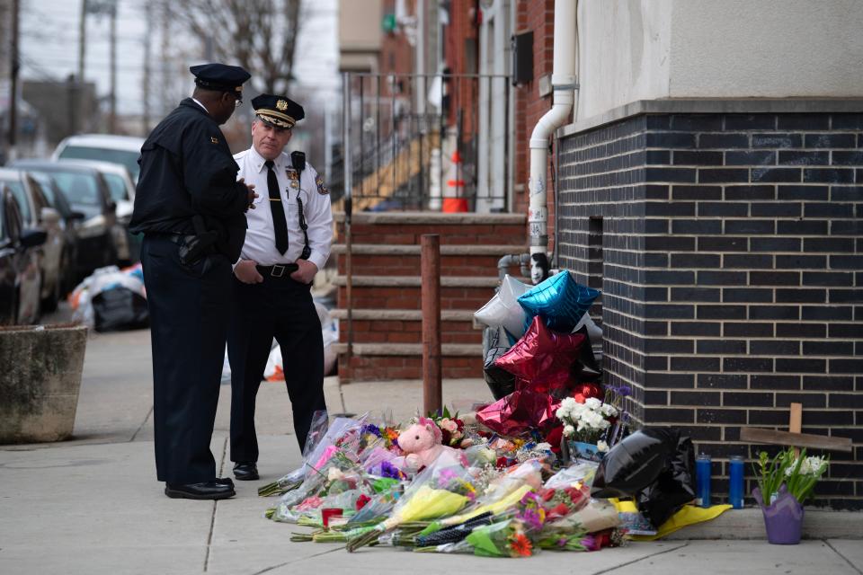 Captain Michael Goodson, left, and inspector Ray Evers honor officer Chris Fitzgerald, who was killed while responding to an incident, by visiting the memorial made for him on the intersection of West Montgomery Avenue and North Bouvier Street in North Philadelphia on Monday, Feb. 20, 2023.