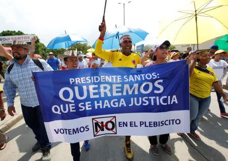 Demonstrators hold a sign reading "President Santos, we want justice, let's vote NO in the plebiscite," during a protest against the government's peace accord with the Revolutionary Armed Forces of Colombia (FARC) which would allow rebels to enter parliament without serving any jail time, in Cartagena, Colombia, September 26, 2016. REUTERS/John Vizcaino