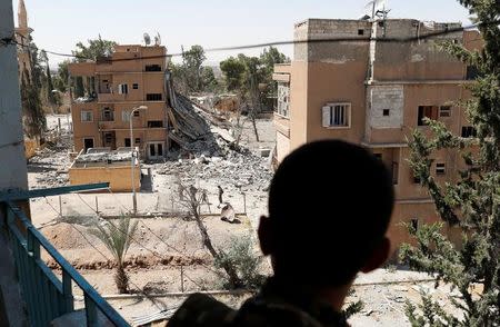 FILE PHOTO: A Syrian Democratic Forces (SDF) fighter stand in a balcony in Raqqa, Syria June 27, 2017. REUTERS/Goran Tomasevic