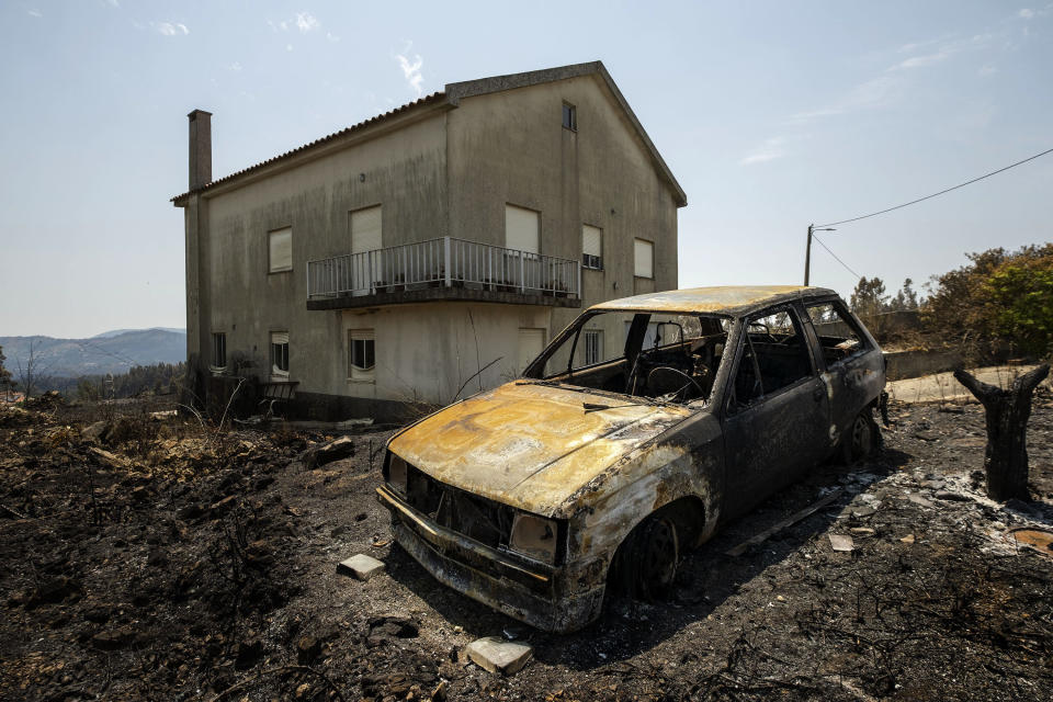 A burnt car is seen following a fire near Roda, in central Portugal on Tuesday, July 23, 2019. Emergency services in Portugal have brought under control a huge wildfire which raged for four days and injured 39 people. Civil Protection Agency commander Luis Belo Costa says around 1,000 firefighters are watching out for smoldering hotspots amid temperatures close to 40 degrees Celsius and gusting winds. (AP Photo/Sergio Azenha)