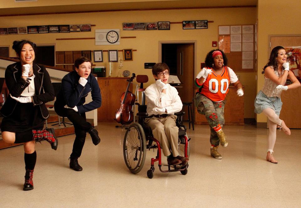 The cast of glee dancing in season one choir room