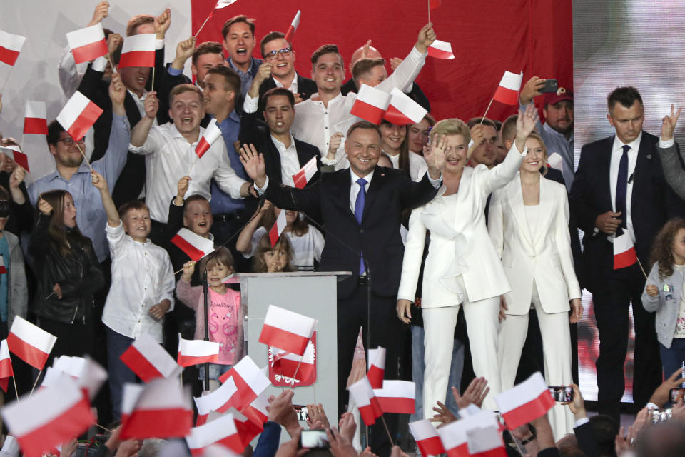 Incumbent President Andrzej Duda, left, and his wife Agata Kornhauser-Duda wave to supporters in Pultusk, Poland, Sunday, July 12, 2020. Conservative Duda ran against liberal Warsaw Mayor Rafal Trzaskowski in a razor-blade-close presidential election runoff and exit poll shows election is too close to call. (AP Photo/Czarek Sokolowski)