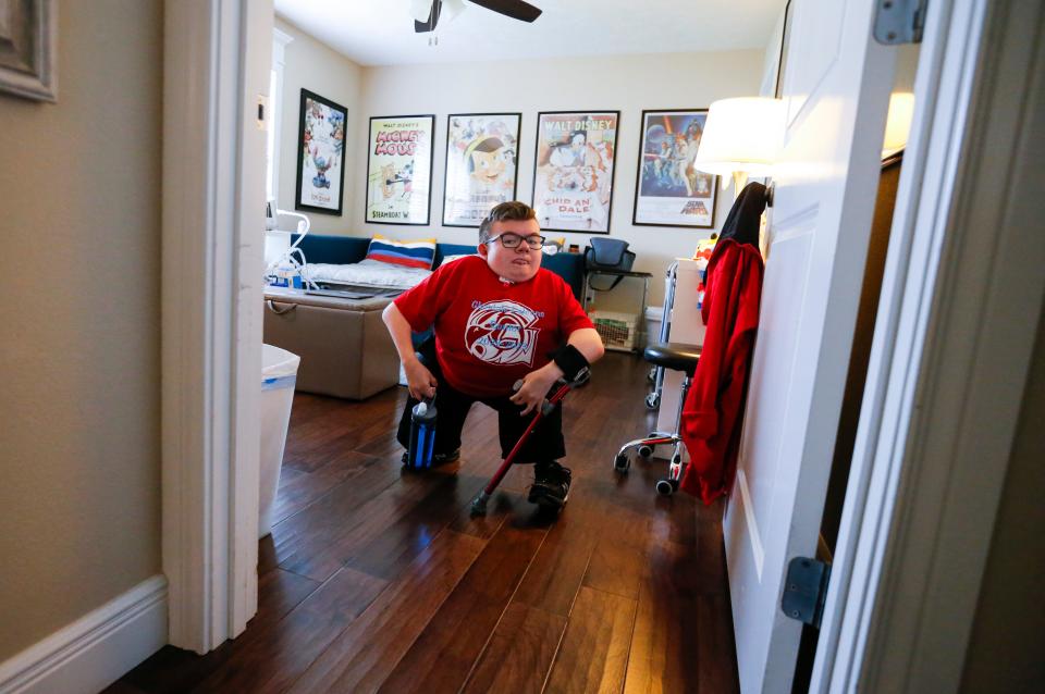 Glendale High School senior Collin Langston walks out from his bedroom on Thursday, May 11, 2023. Langston set a goal his freshman year, to walk at graduation and he is going to accomplish that goal.