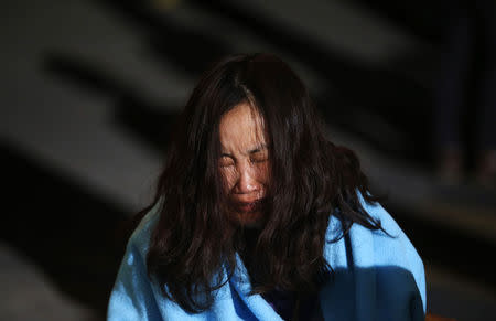 A family member of a missing passenger who was on the South Korean ferry Sewol cries as she waits for a rescue team's arrival at a port in Jindo April 16, 2014. REUTERS/Kim Hong-Ji