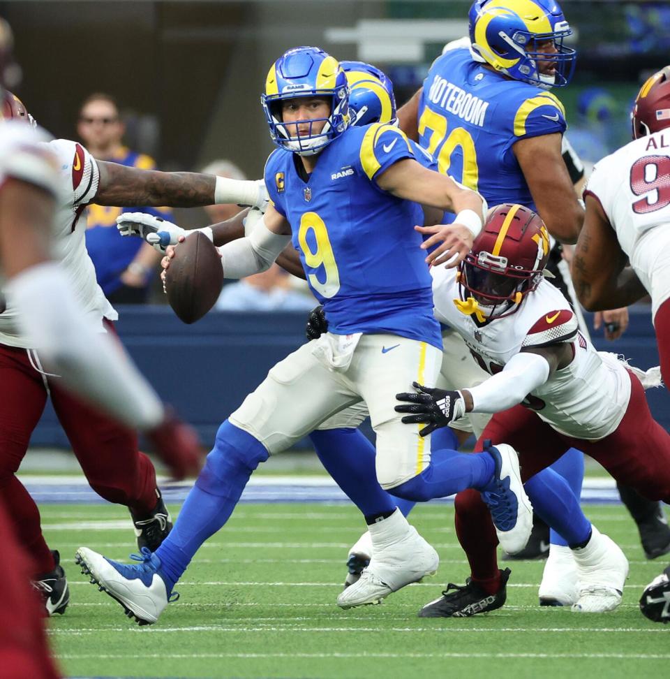 Rams quarterback Matthew Stafford scrambles as he looks for a receiver against the Commanders.