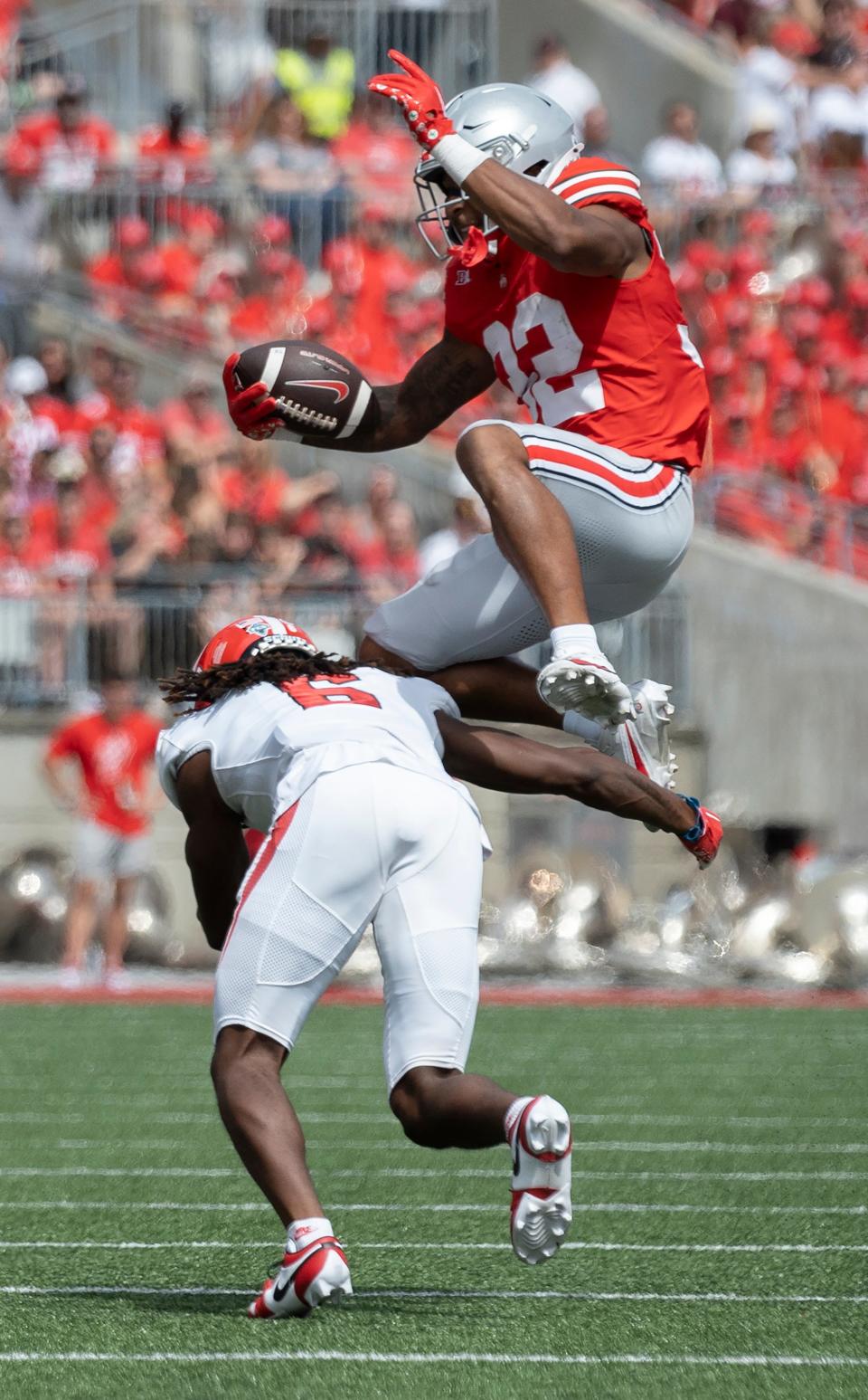 Ohio State running back TreVeyon Henderson leaps over Youngstown State defensive back Ezekiel Blake on Saturday.