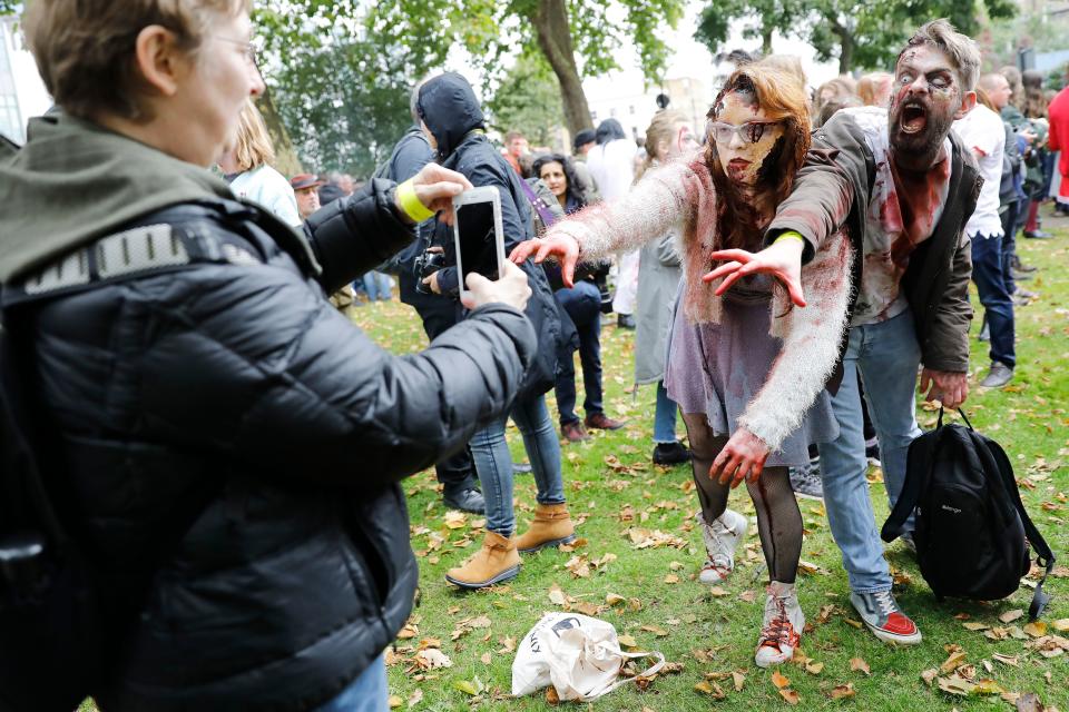 <p>People pose for a photograph before participating in a zombie walk on World Zombie Day in London on Oct. 7, 2017. (Photo: Tolga Akmen/AFP/Getty Images) </p>
