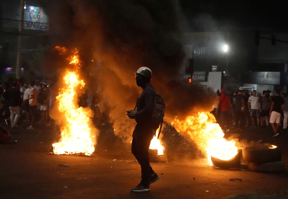 Partidarios del líder opositor y gobernador de Santa Cruz Luis Fernando Camacho protestan en una barricada en llamas, en Santa Cruz, Bolivia, el 3 de enero de 2023. (AP Foto/Juan Karita)