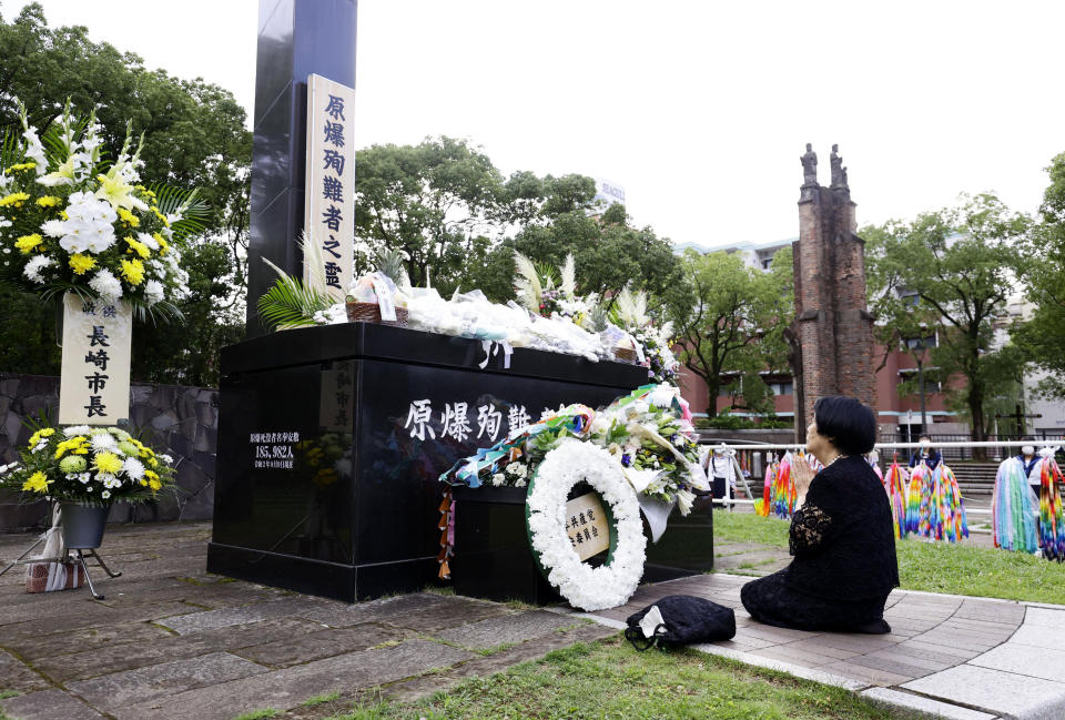 A bereaved family member prays for the victims of U.S. atomic bombing at the Atomic Bomb Hypocenter Park in Nagasaki, southern Japan, Sunday, Aug. 9, 2020. Nagasaki marked the 75th anniversary of the atomic bombing on Sunday. (Kyodo News via AP)