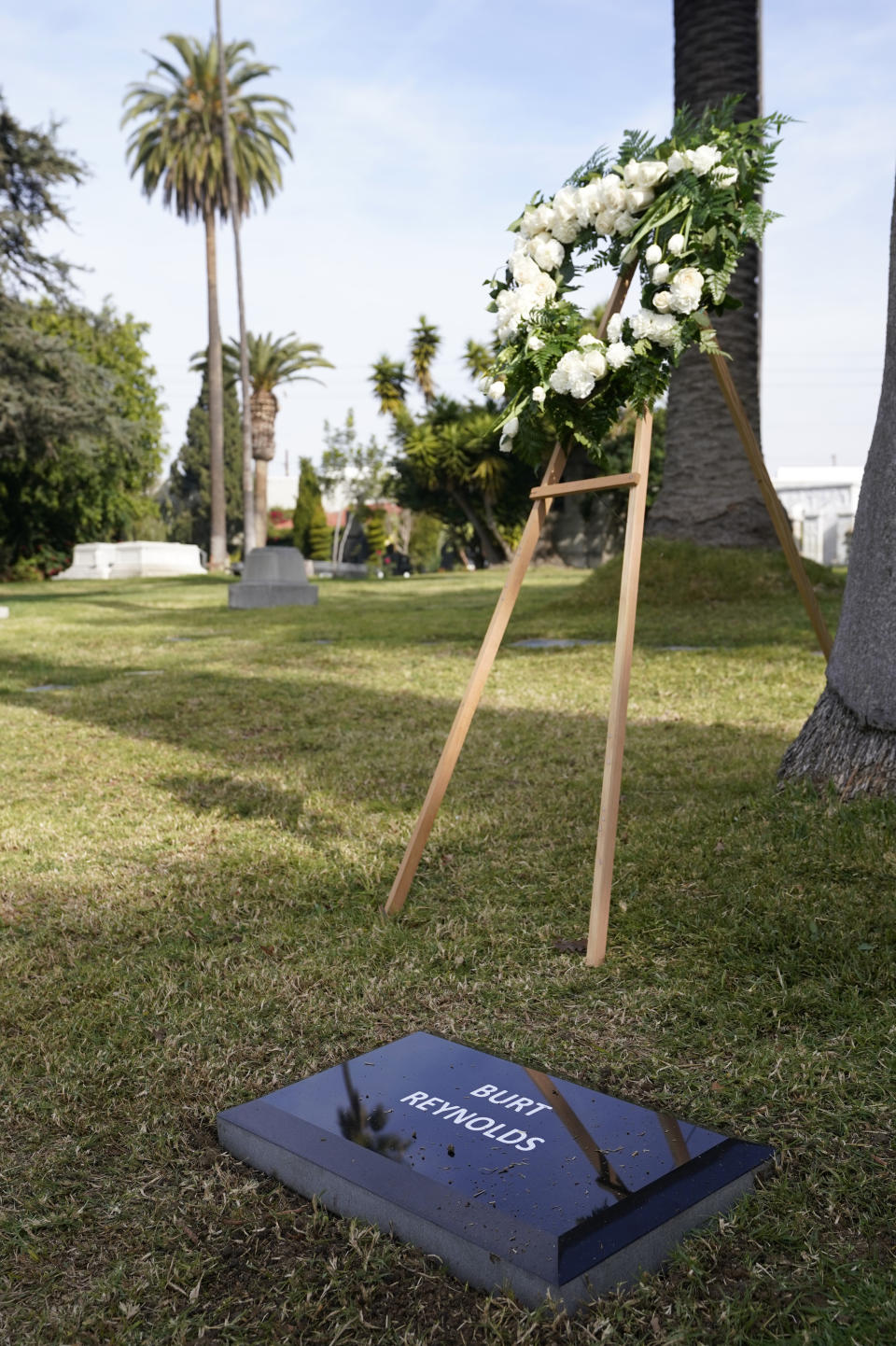 A temporary headstone for the late actor Burt Reynolds is pictured in the Garden of Legends section of Hollywood Forever cemetery, Thursday, Feb. 11, 2021, in Los Angeles. Reynolds' cremated remains were moved from Florida to Hollywood Forever, where a small ceremony was held Thursday. A permanent gravesite will be put up for Reynolds in a few months. (AP Photo/Chris Pizzello)