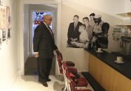 Rodney Hurst visits a replica of the lunch counter where he took part in a peaceful demonstration to protest the discrimination faced by Blacks, at a display at at the Ritz Theater, on Friday, Oct. 23, 2020, in Jacksonville, Fla. In the background is a blow up of a photo taken in 1960 when he was 16. After leaving the lunch counter in downtown Jacksonville as a teen, a mob of whites began indiscriminately clubbing African Americans with baseball bats and ax handles during a day now remembered as Ax Handle Saturday. (AP Photo/Bobby Caina Calvan)