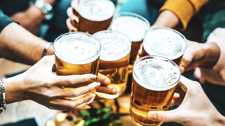 Group of people toasting beers in hand