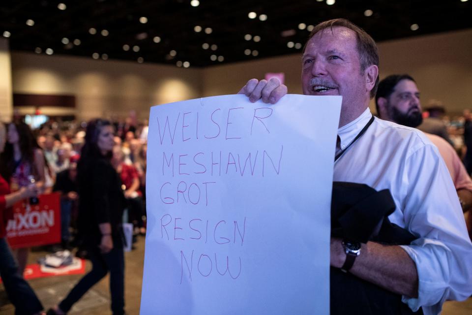 Charles Ritchard, a delegate from District 2 holds up a sign asking Ron Weiser and Meshawn Maddock to resign during the MIGOP State Nominating Convention at the Lansing Center in Lansing on Saturday, August 27, 2022.