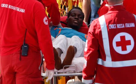 A migrant is seen in on a stretcher after disembarking at the Sicilian port of Catania, Italy, October 4, 2016. REUTERS/Antonio Parrinello