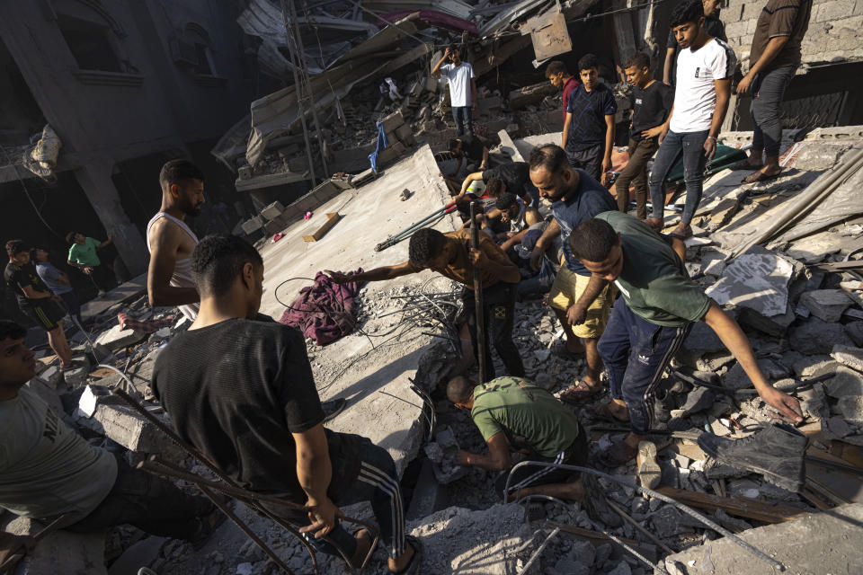 Palestinians search for bodies and survivors in the rubble of a residential building leveled in an Israeli airstrike, in Al Shati refugee camp Thursday, Oct. 12, 2023. Israel's retaliation has escalated after Gaza's militant Hamas rulers launched an unprecedented attack on Israel Saturday, killing over 1,200 Israelis and taking captive dozens. Heavy Israeli airstrikes on the enclave has killed over 1,200 Palestinians. (AP Photo/Fatima Shbair)