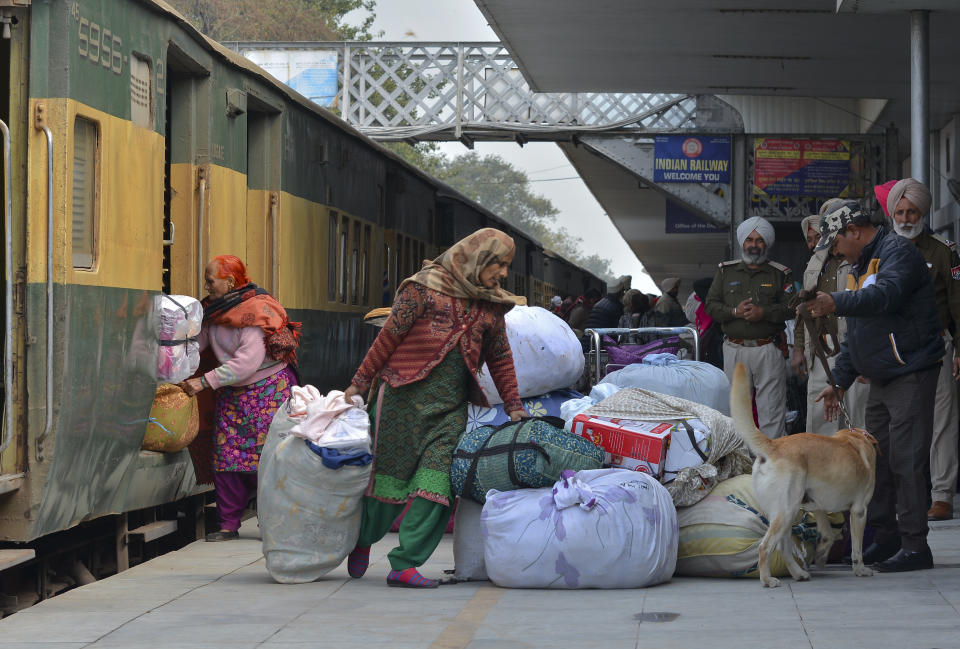 Passengers from Pakistan unload their belongings from the Samjhauta Express train as it arrives in Atari, India, Monday, March 4, 2019. A Pakistani railway official said the key train service with neighboring India has resumed in another sign of easing tensions between the two nuclear-armed rivals since a major escalation last week over disputed Kashmir region. (AP Photo/Prabhjot Gill)