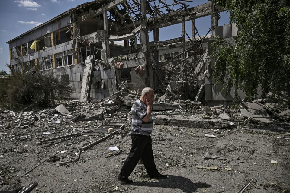 A local resident reacts in front of a destroyed school after a strike in the city of Bakhmut, eastern Ukrainian region of Donbas on 8 June (AFP via Getty Images)