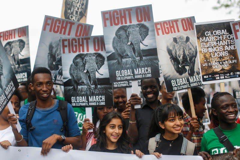 Demonstrators hold up placards as they march in support of protecting elephants, rhinos and lions and to raise awareness that they are endangered species, in downtown Nairobi, Kenya on 15 October 2016. (EPA)