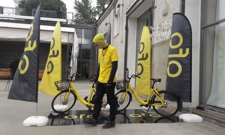 A participant stands next to bicycles during a presentation, organized by bike-sharing startup Ofo, in Moscow, Russia September 22, 2017. REUTERS/Denis Pinchuk/Files