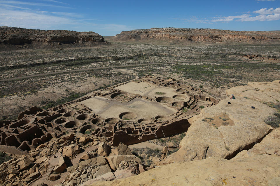 FILE - A hiker sits on a ledge above Pueblo Bonito, the largest archeological site at the Chaco Culture National Historical Park, in northwestern New Mexico, on Aug. 28, 2021. The Biden administration is implementing a 20-year withdrawal banning oil and gas development outside the boundaries of Chaco Culture National Historical Park in northwestern New Mexico. The action taken by Secretary of the Interior Deb Haaland in the nation’s No. 2 oil-producing state was announced Friday June 2, 2023. (AP Photo/Cedar Attanasio, File)