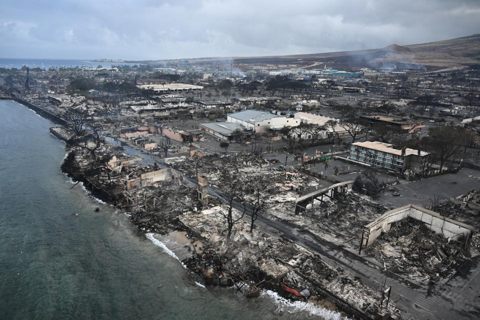 An aerial image shows Old Lahaina Center and Foodland Lahaina standing amongst destroyed homes and businesses along Front Street burned to the ground in the historic Lahaina in the aftermath of wildfires in western Maui in Lahaina, Hawaii on August 10, 2023.