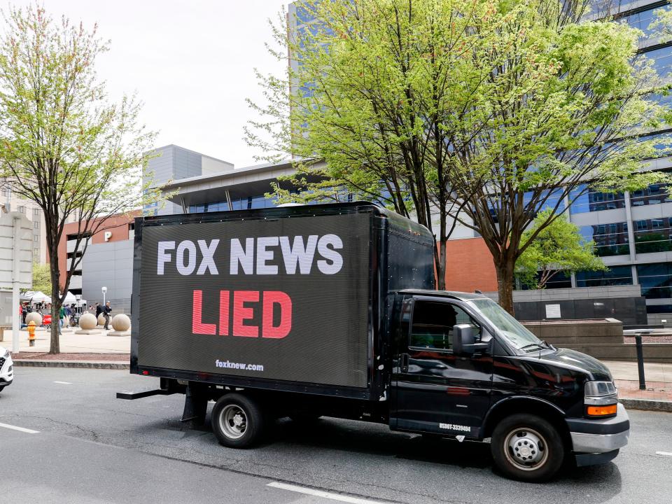 A black truck with the words "FOX NEWS LIED" on the side.