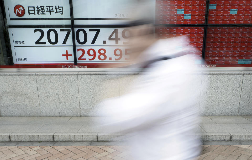 A man walks past an electronic stock board showing Japan's Nikkei 225 index at a securities firm in Tokyo Wednesday, June 5, 2019. Shares surged Wednesday in Asia following a rally on Wall Street spurred by signs the Federal Reserve is ready to cut interest rates to support the U.S. economy against risks from escalating trade wars. (AP Photo/Eugene Hoshiko)