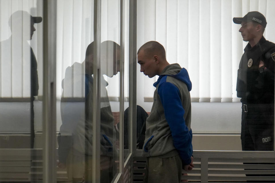 Russian Sgt. Vadim Shishimarin stands in court during a hearing in Kyiv, Ukraine, Thursday, May 19, 2022. The 21 year old Russian soldier facing the first war crimes trial since the start of the war in Ukraine testified Thursday that he shot a civilian on orders from two officers and pleaded for his victim's widow to forgive him. (AP Photo/Roman Hrytsyna)