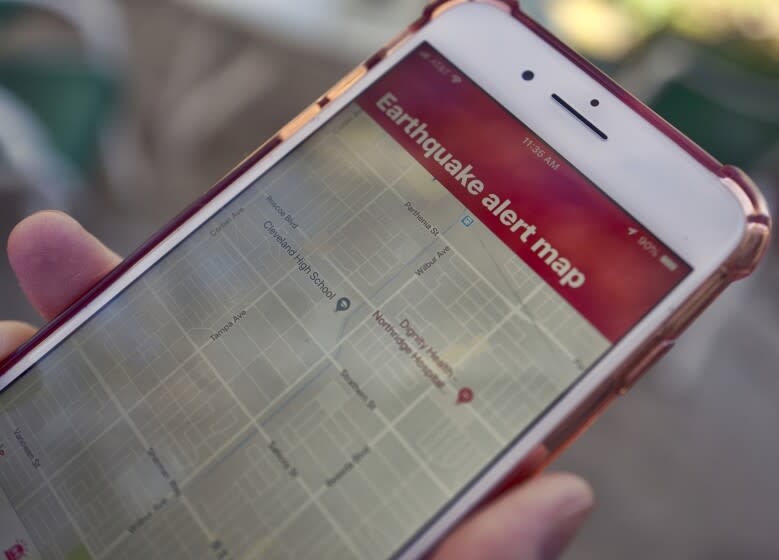 FILE - In this Jan. 3, 2019 file photo a mobile phone customer looks at an earthquake warning application on their phone in Los Angeles. Earthquake early warning alerts will become publicly available throughout California for the first time this week, potentially giving people time to protect themselves from harm, the Governor's Office of Emergency Services said Wednesday, Oct. 16, 2019. Warnings produced by the ShakeAlert system will be pushed through two delivery systems: a cellphone app called MyShake and the same wireless notification system that issues Amber Alerts, meaning people may receive both notifications. (AP Photo/Richard Vogel, File)