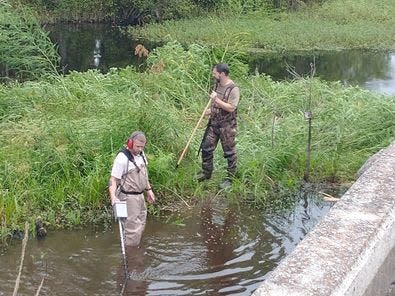 SLED teams use metal detectors to comb a stretch of the Coosawhatchie River.