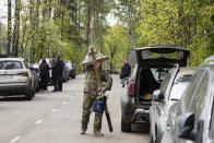 A man carries a wooden cross near the entrance of a cemetery outside Moscow, Russia, Tuesday, May 26, 2020. Russia reported more than 360,000 confirmed coronavirus cases on Tuesday and more than 3,800 deaths. (AP Photo/Pavel Golovkin)