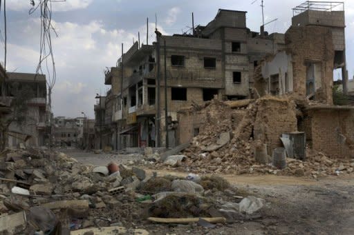 Damage and destruction litter a street in the battered city of Qusayr, southwest of Homs in western Syria. The Red Cross said Wednesday it will try to evacuate hundreds of civilians trapped by fierce fighting in and around the restive city of Homs, as violence killed dozens of people across Syria