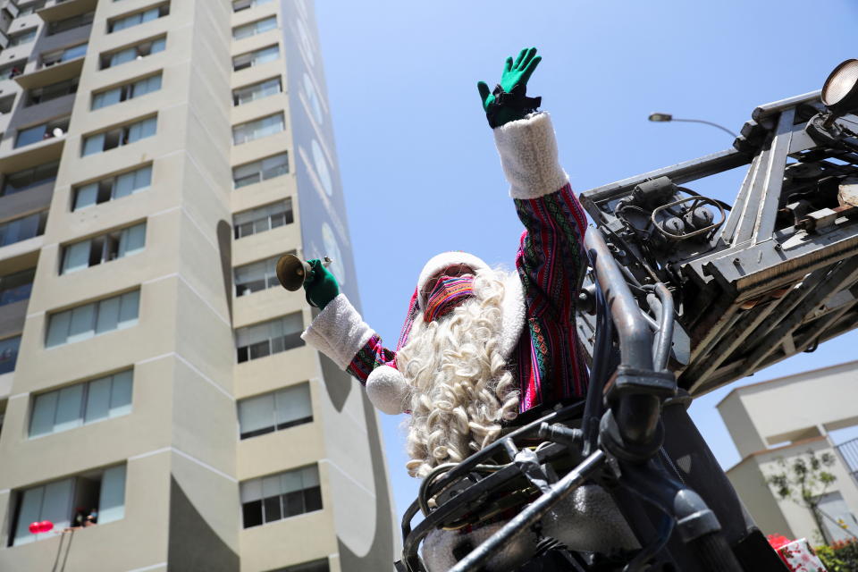 Paul Heinz Suarez Gamarra, locally known as the Peruvian Santa Claus, waves before getting a lift  from the local volunteer firefighter brigade, before handing out presents to young coronavirus disease (COVID-19) patients at a hospital, in Lima, Peru December 14, 2021. REUTERS/Sebastian Castaneda