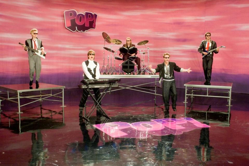 Hugh Grant (second from left) with fictional pop group PoP! in the music video for ‘Pop Goes My Heart’ (Moviestore/Shutterstock)