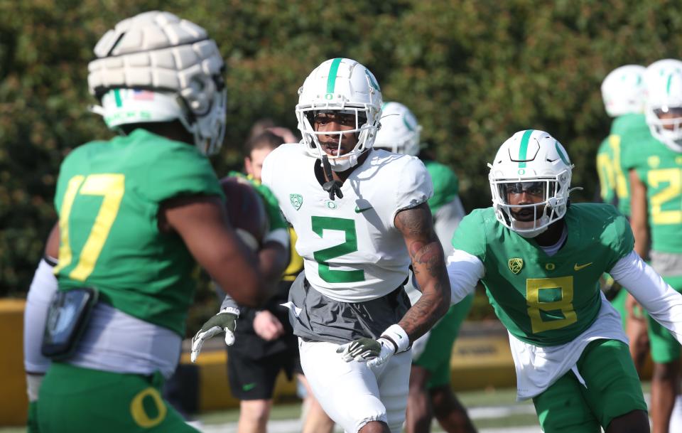 Outside linebacker Jabril McNeill, left, receiver Dont'e Thornton and DB Dontae Manning join a drill at Oregon football spring practice March 31, 2022.