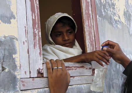 A girl from a group Rohingya and Bangladeshi migrants, who arrived in Indonesia by boat this week, receives a bottle of water from a local resident after arriving at a new shelter in Lhoksukon, Indonesia's Aceh Province May 13, 2015. REUTERS/Roni Bintang