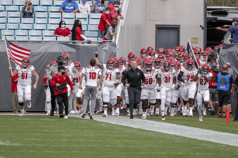 JACKSONVILLE, FL - JANUARY 2: Head Coach Dave Doeren of the North Carolina State Wolfpack leads his team on to the field before the start of the game against the University of Kentucky Wildcats at the 76th annual TaxSlayer Gator Bowl at TIAA Bank Field on January 2, 2021 in Jacksonvile, Florida.  (Photo by Don Juan Moore/Getty Images)