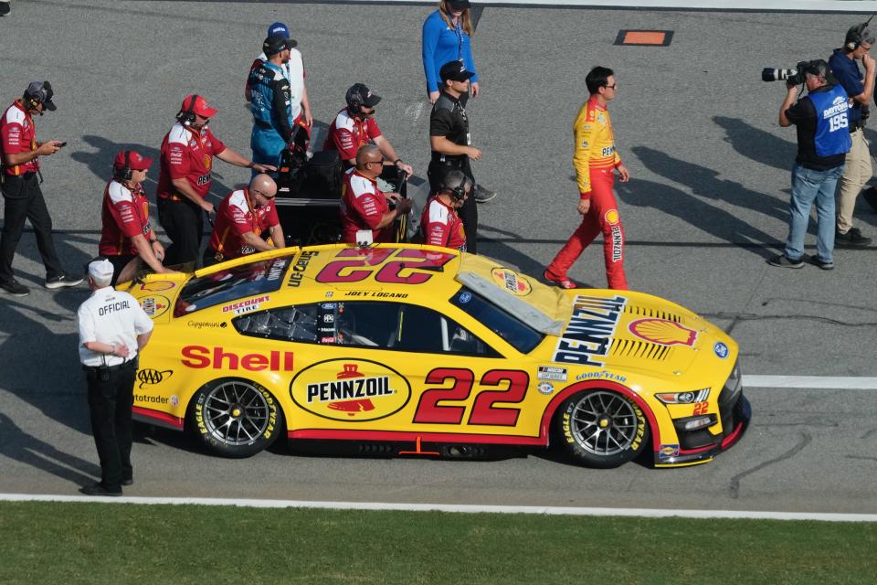 Joey Logano and his crew walk the No. 22 Team Penske Ford out onto pit road prior to qualifying for the Coke Zero Sugar 400 on Friday.