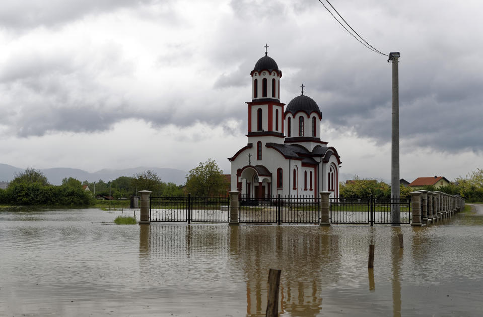 The yard around the Orthodox church is flooded after heavy rains in Prijedor, Bosnia-Herzegovina, Tuesday, May 14, 2019. Homes and roads have been flooded in parts of Bosnia after rivers broke their banks following heavy rains, triggering concerns Tuesday of a repeat of floods five years ago when dozens died. (AP Photo/Darko Bandic)