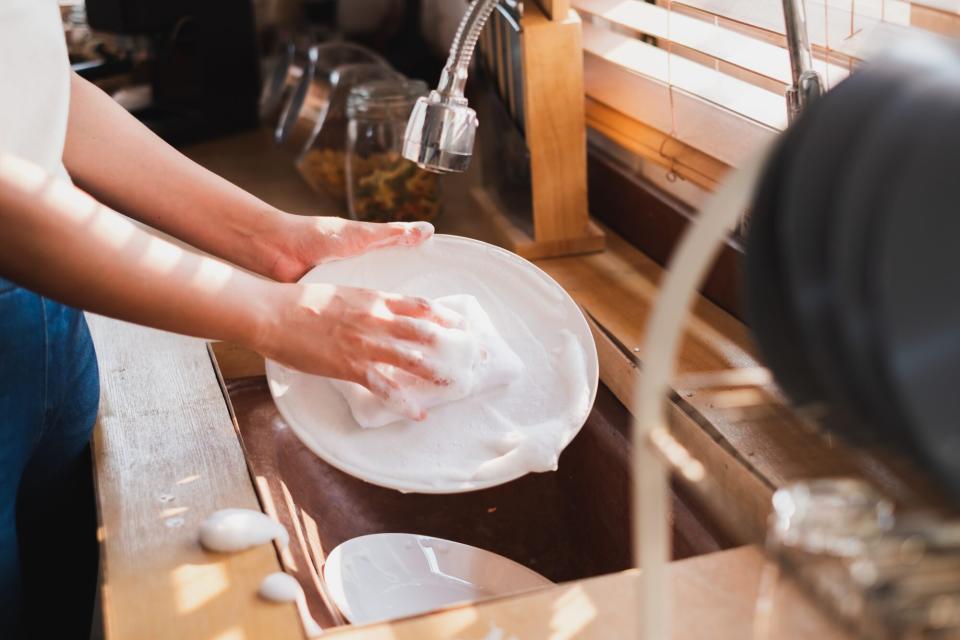 close up of of washing dishes in sink