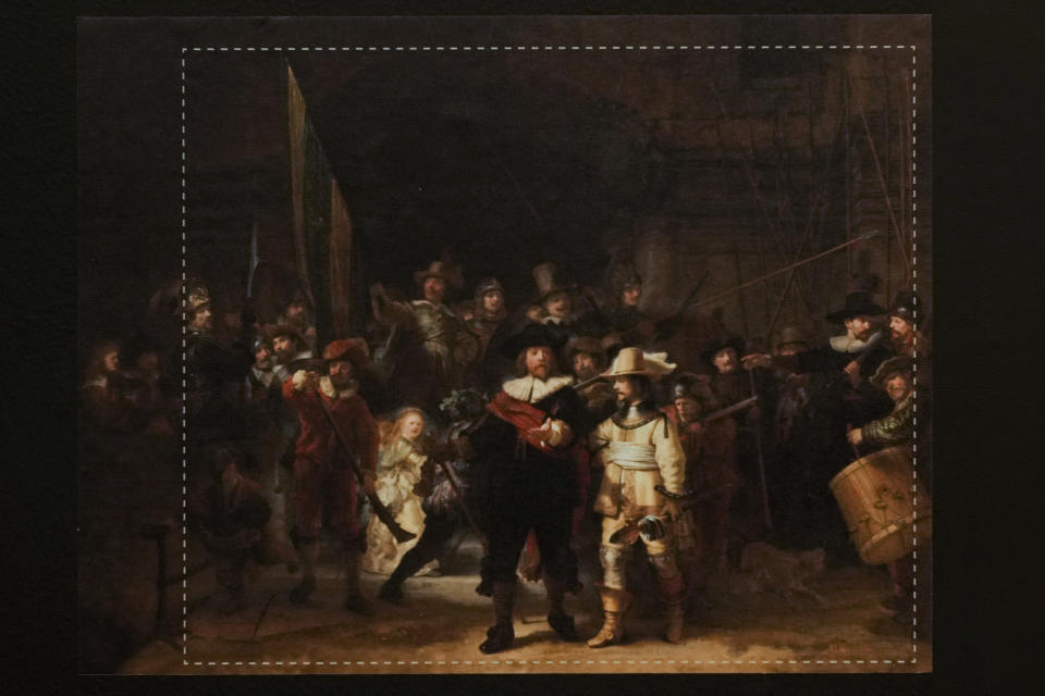 A photograph with lines showing the added parts explains how Rembrandt's biggest painting the Night Watch just got bigger with the help of artificial intelligence in Amsterdam, Netherlands, Wednesday, June 23, 2021. The Dutch national museum and art gallery reveals findings from a long-term project to examine in minute detail Rembrandt van Rijn's masterpiece the Night Watch.(AP Photo/Peter Dejong)