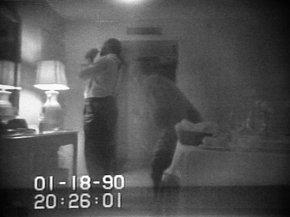 This file frame from a black-and-white FBI videotape shows Washington Mayor Marion Barry allegedly lighting a crack cocaine pipe in a Washington hotel room in January 18, 1990 as Rasheeda Moore stands behind him. (Barry Thumma/AP)