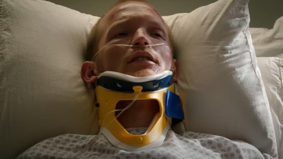 Jimmy in a neck brace laying on a hospital bed in Yellowstone.