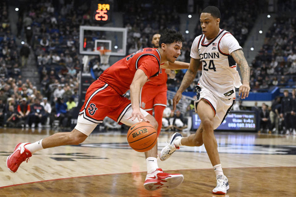 St. John's Rafael Pinzon, left, drives to the basket as UConn's Jordan Hawkins defends in the second half of an NCAA college basketball game, Sunday, Jan. 15, 2023, in Hartford, Conn. (AP Photo/Jessica Hill)