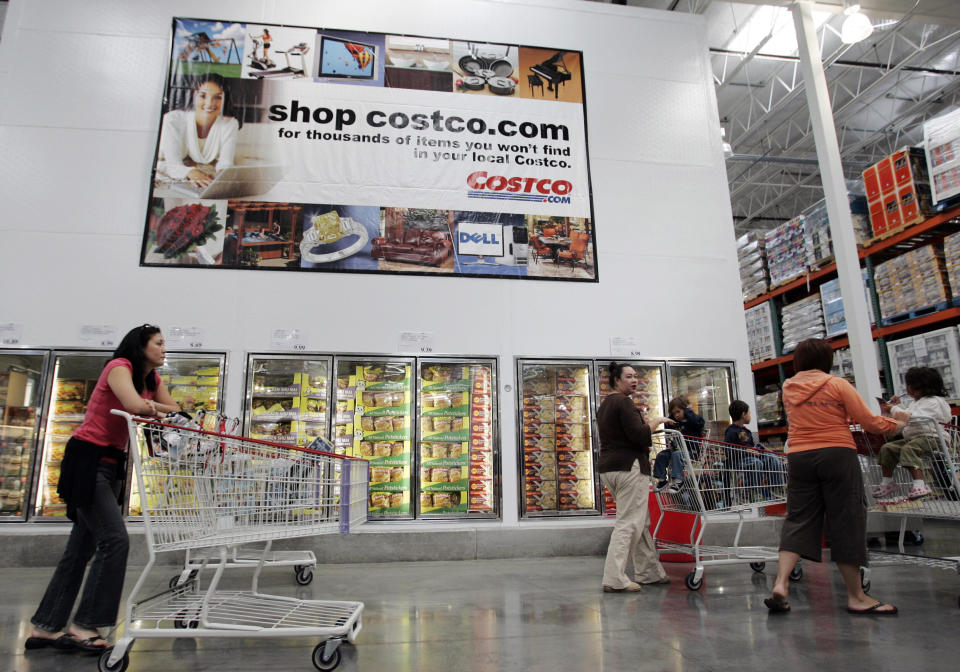 Costco shoppers walk next to an advertisement for Costco online at a Costco store in San Jose, Calif., Tuesday, Oct. 9, 2007.   Shares of Costco Wholesale Corp. jumped nearly 10 percent Wednesday, Oct. 10 after the discount retailer said its fiscal fourth-quarter profit rose 5 percent on increased membership fee revenue and higher same-store warehouse sales. (AP Photo/Paul Sakuma)