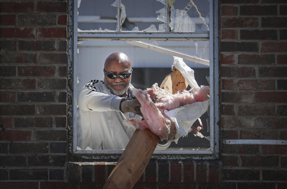 Joseph Mack helps helps neighbor Patrick Glover clean up his house in Covington, Tenn., Saturday, April 1, 2023 after it was hit by tornado. Storms that spawned possibly dozens of tornadoes have killed several people in the South and Midwest. (Patrick Lantrip/Daily Memphian via AP)