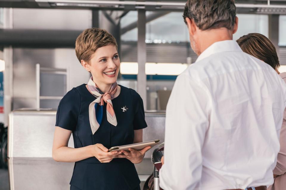 Smiling airline employee talking to couple at the airport