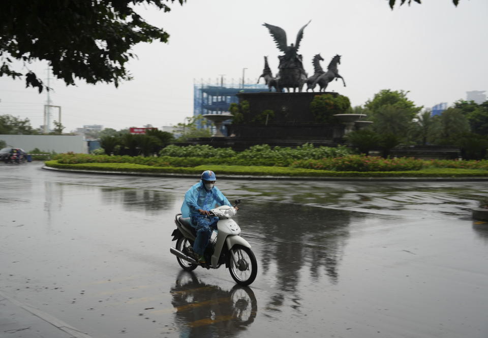 Un hombre circula en motocicleta bajo la lluvia provocada por el tifón Yagi, en Hanói, Vietnam, el 7 de septiembre de 2024. (AP Foto/Hau Dinh)